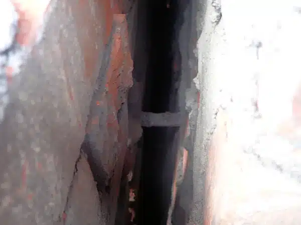 A cavity view of a metal wall tie which appears intact but has failed due to corrosion