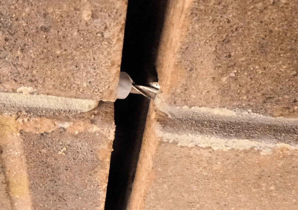 A close-up of an installed slip-tie in a partially completed retro-fit movement joint