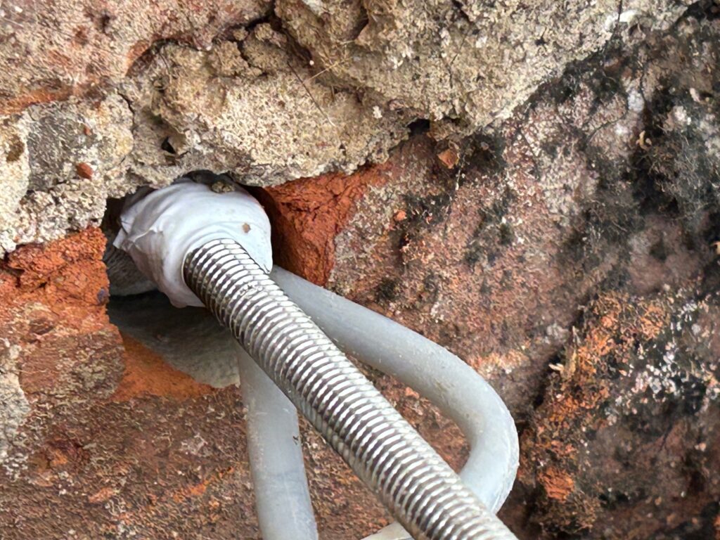 Close up of a Cintec grouted sock ancho in postion awaiting connection to a lateral restraint strap to fix bulging walls.