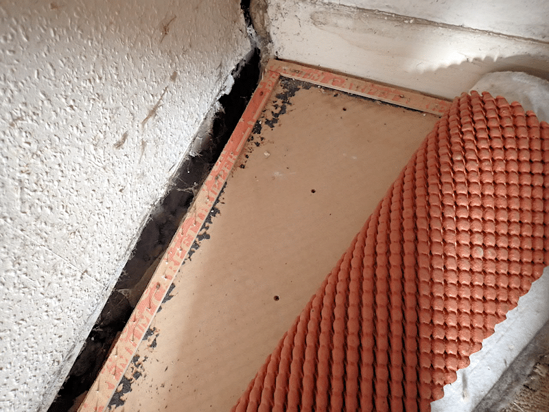 A carpet pulled back to reveal structural movement in a house