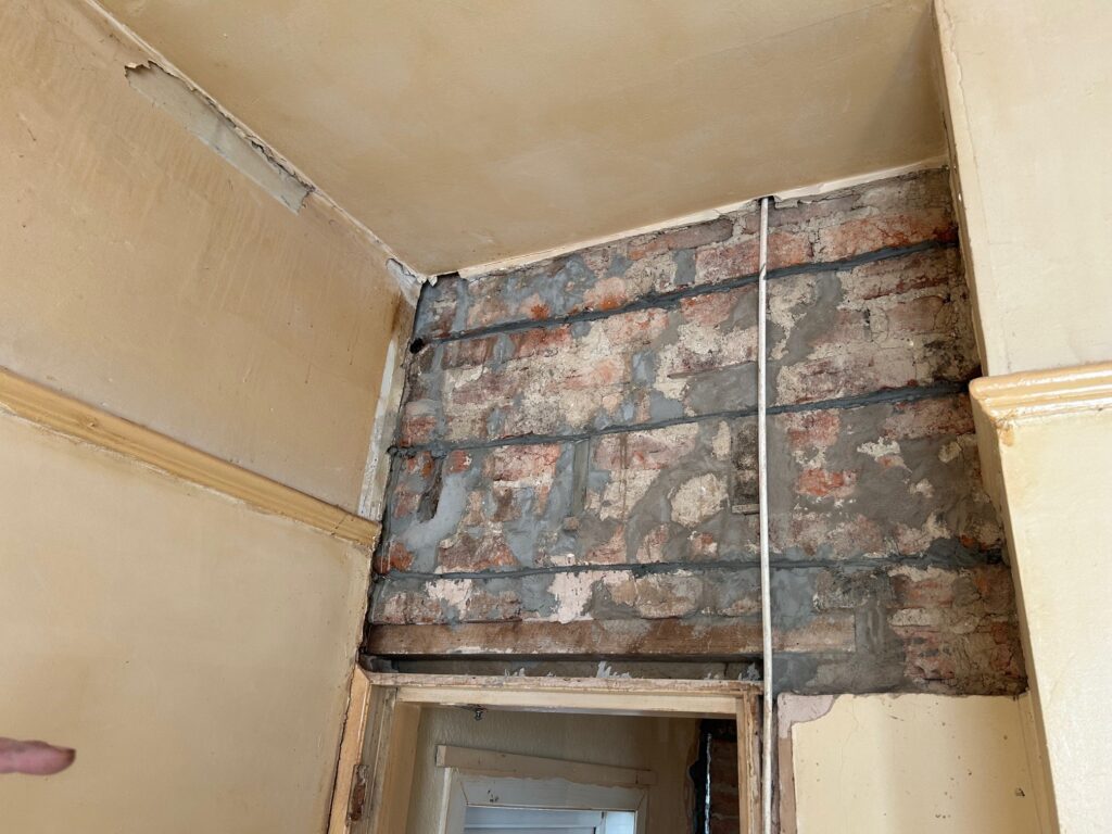 An old internal brickwork panel with failure cause by excessive lateral forces.